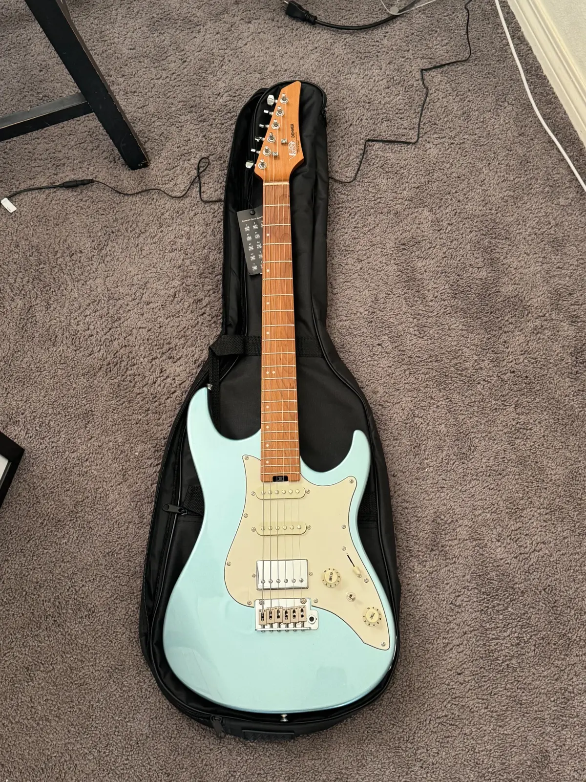 Travis's light blue electric guitar resting inside its black gig bag