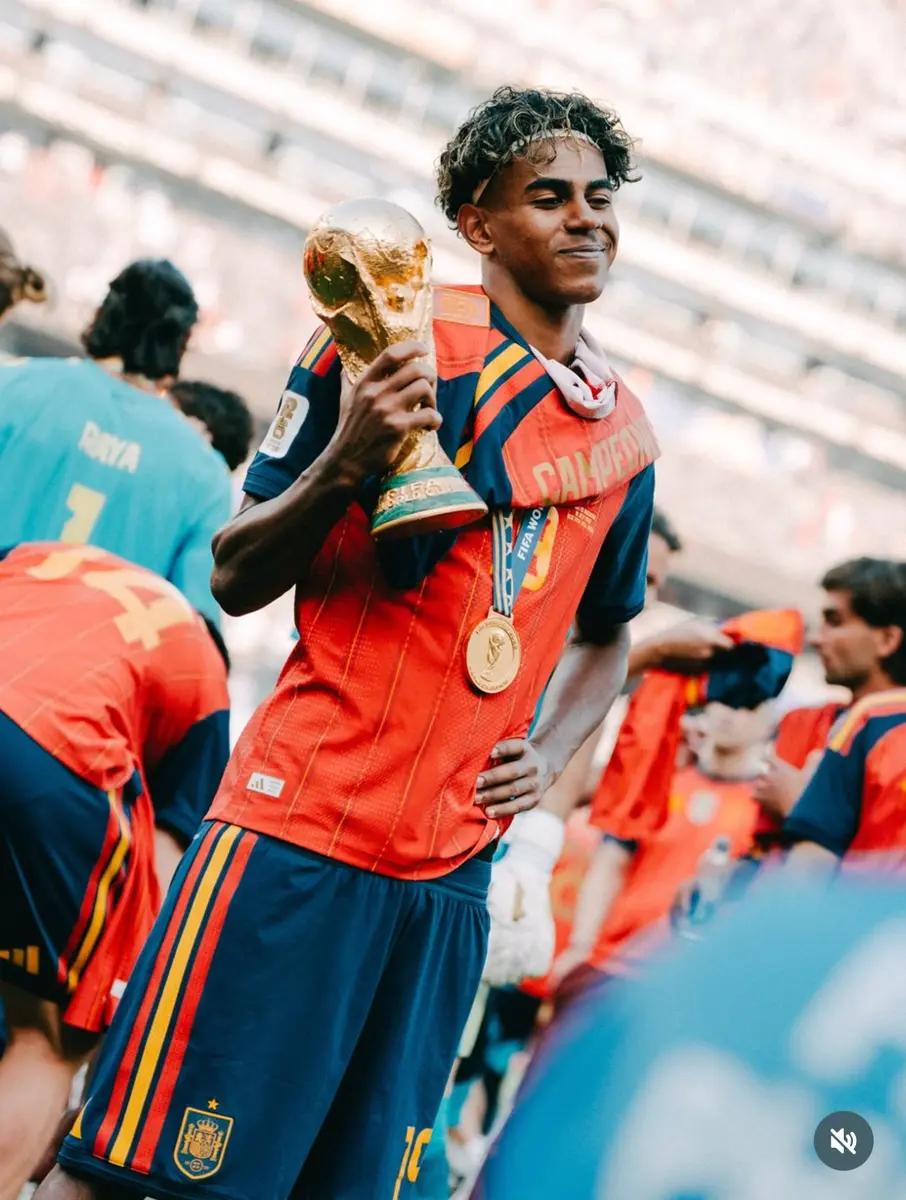 Lamine Yamal holding a championship trophy with Spain