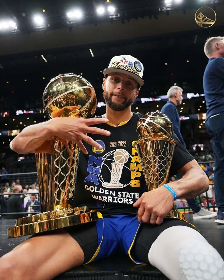 Stephen Curry holding the NBA championship and Finals MVP trophies
